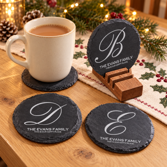4 slate coasters with initials and text, a coffee cup on a slate coaster